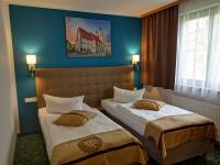 Dos camas en una habitación de hotel con paredes azules. en ACRON Hotel Wittenberg, en Lutherstadt Wittenberg