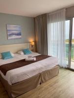 a hotel room with a large bed and a large window at Hotel Europa in Quiberon