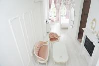 a white bathroom with pink chairs and a mirror at Milk White Homestay in Hengchun South Gate