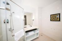 a white bathroom with a sink and a shower at Sunseed International Villa Hotel in Chiayi City