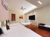 a bedroom with two beds and a flat screen tv at Qixingtan Xinghai B&amp;B in Dahan