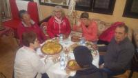 grupa ludzi siedząca przy stole i jedząca jedzenie w obiekcie riad lala fatima w mieście Ouzoud