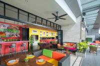 a living room with colorful furniture and a bar at Eastin Grand Hotel Sathorn in Bangkok
