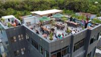 people standing on the roof of a building with tables and umbrellas at Maa Thundi in Fuvahmulah