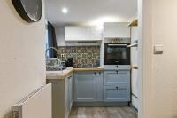 a kitchen with white cabinets and a stove top oven at Large and calm flat in the heart of Lille - Welkeys in Lille
