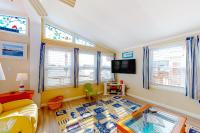 ein Wohnzimmer mit einem Sofa, einem TV und Fenstern in der Unterkunft Montego Bay - 197 Pine Tree Road in Ocean City