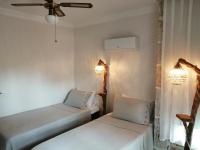 2 camas en una habitación con paredes blancas y luces en Villa Citronella Boutique Hotel, en Antalya