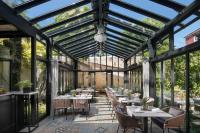 un giardino d'inverno con tavoli, sedie e finestre di Almayer Art & Heritage Adults Only Hotel and Dépendance rooms a Zara (Zadar)