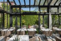 una sala da pranzo con tavoli, sedie e finestre di Almayer Art & Heritage Adults Only Hotel and Dépendance rooms a Zara (Zadar)