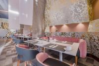 uma sala de jantar com mesas e cadeiras cor-de-rosa em Radisson Blu Gautrain Hotel, Sandton Johannesburg em Joanesburgo