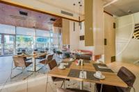 uma sala de jantar com mesas e cadeiras de madeira em Radisson Blu Gautrain Hotel, Sandton Johannesburg em Joanesburgo