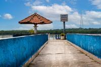 a walkway with an umbrella and a sign on a bridge at Hotel Marina Clube de Pesca in Cananéia