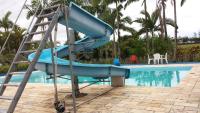 a blue water slide next to a swimming pool at Hotel Marina Clube de Pesca in Cananéia