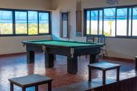 a pool table in a room with two stools at Hotel Marina Clube de Pesca in Cananéia