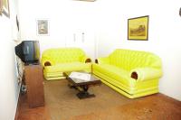 a living room with two yellow couches and a tv at Hotel Marina Clube de Pesca in Cananéia