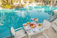 una mesa con desayuno junto a la piscina en Paradise Inn Beach Resort, en Alejandría
