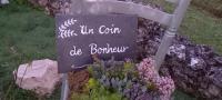 a sign in front of a garden with flowers at La Maison Josnes de Mady in Josnes