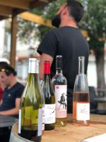 three bottles of wine sitting on a table with a man at Grand hôtel de l&#39;Europe in Vals-les-Bains