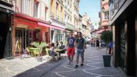 two men are walking down a city street at Le Cosy green - Appart 3ch + balcon - neuf in Saint Etienne