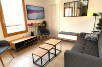 a living room with a couch and a table at Le Cosy green - Appart 3ch + balcon - neuf in Saint Etienne