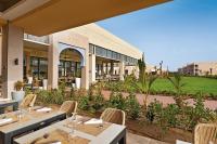 a restaurant with tables and chairs in front of a building at Hotel Riu Baobab - All Inclusive in Pointe-Sarène