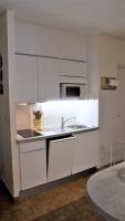 a kitchen with white cabinets and a sink at valras appartement T2 proche mer et port in Valras-Plage