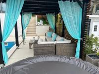 eine Terrasse mit einem Sofa und blauen Vorhängen in der Unterkunft Apartman Mateo in Njivice
