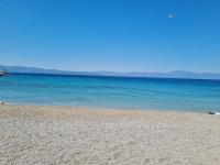 einen Strand mit blauem Wasser und Bergen im Hintergrund in der Unterkunft Apartman Mateo in Njivice