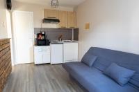 a living room with a blue couch and a kitchen at Le Petit Mondi in Mareuil-sur-Cher