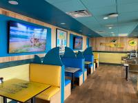 a dining room with blue chairs and a large screen at Margaritaville Beach Resort South Padre Island in South Padre Island