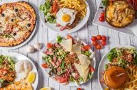 a table topped with plates of food and pasta at The Originals Access, Hôtel Foix in Foix