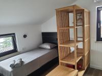 a bedroom with a bed with a wooden book shelf at Apartments Krista Medveja in Medveja