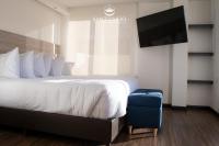 Una habitación de hotel con una cama y un televisor de pantalla plana. en HOTEL SANTUARIO, en Tunja