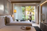 a woman standing in a hotel room with two beds at Jumeirah Muscat Bay Oman in Muscat