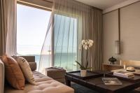 a living room with a couch and a large window at Jumeirah Muscat Bay Oman in Muscat