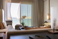 a living room with a couch and a large window at Jumeirah Muscat Bay Oman in Muscat