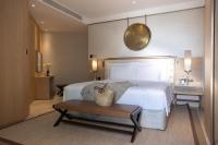 a bedroom with a large white bed and a table at Jumeirah Muscat Bay Oman in Muscat