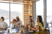 a group of people sitting around a table eating food at Jumeirah Muscat Bay Oman in Muscat