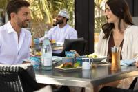 a group of people sitting at a table eating food at Jumeirah Muscat Bay Oman in Muscat