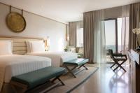 a hotel room with two beds and a balcony at Jumeirah Muscat Bay Oman in Muscat