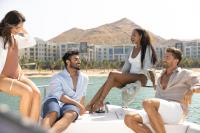 a group of people sitting on a boat in the water at Jumeirah Muscat Bay Oman in Muscat