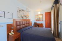 1 dormitorio con 1 cama azul y teléfono en Hotel Terminus &amp; Plaza, en Pisa