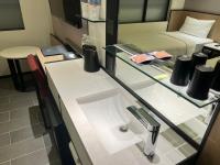 a glass counter with a sink in a room at Hotel Midtown Richardson in Taipei