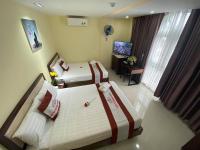 a hotel room with two beds and a television at New Tourane Hotel in Danang