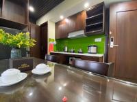 a kitchen with a dining table and a green wall at New Tourane Hotel in Danang
