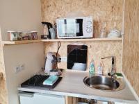 a kitchen counter with a sink and a microwave at Le Garage in Cussy