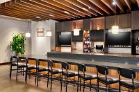a bar with black chairs and a counter with televisions at Hyatt Place Boise/Downtown in Boise