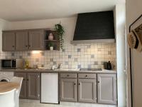 una cocina con armarios blancos y electrodomésticos blancos en Le Grand Appart&#39; proche commerces, en Flers