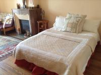 a bedroom with a large bed with a fireplace at La Maison de la Riviere B&amp;B in Espéraza