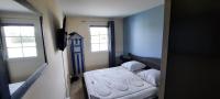 a small bedroom with a bed and two windows at Next to Golf-club House in Talmont